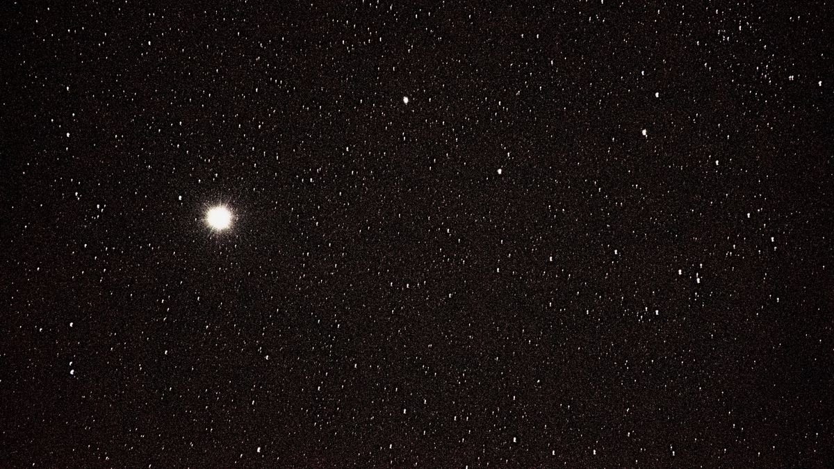 a vast array of stars in a black sky on star left of middle center is extra big and bright