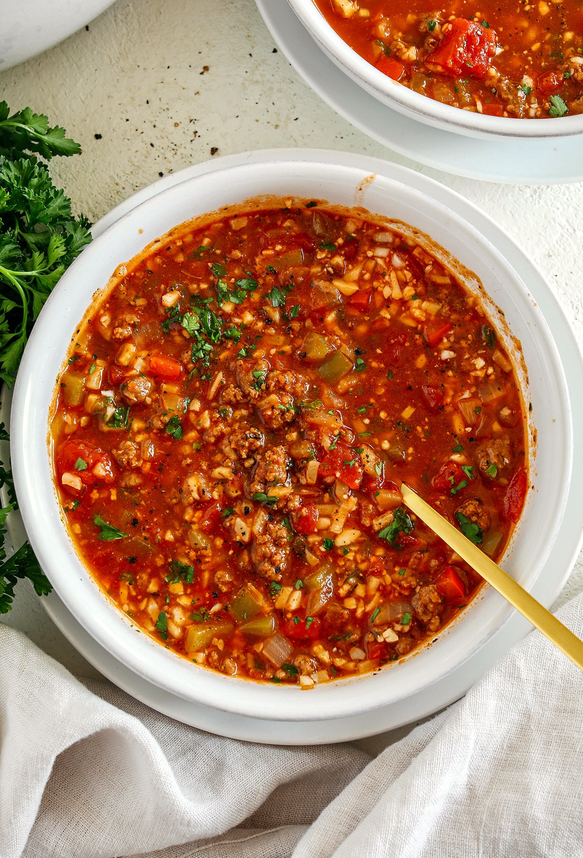 This hearty Stuffed Pepper Soup is loaded with seasoned ground beef colorful bell peppers onion and cauliflower rice all simmered in a flavorful broth for a delicious one pot meal the whole family will love
