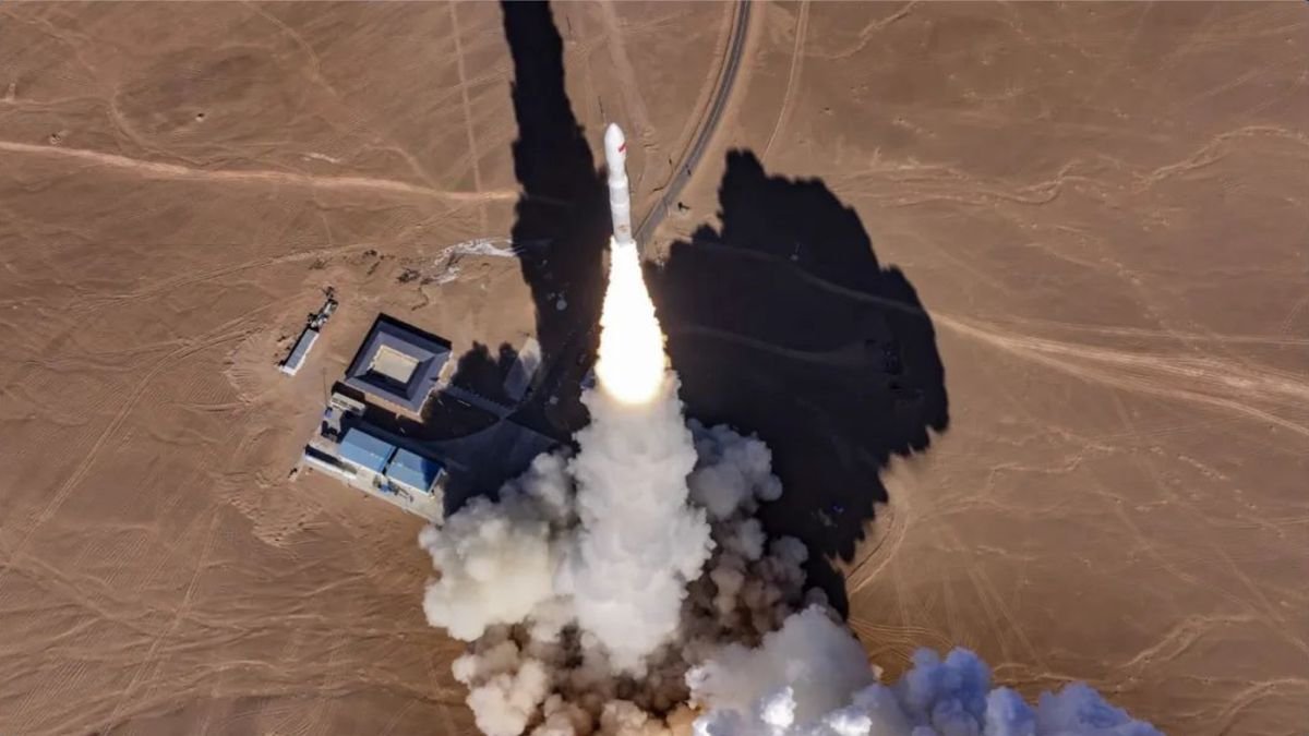 aerial view of a white rocket launching in a desert landscape