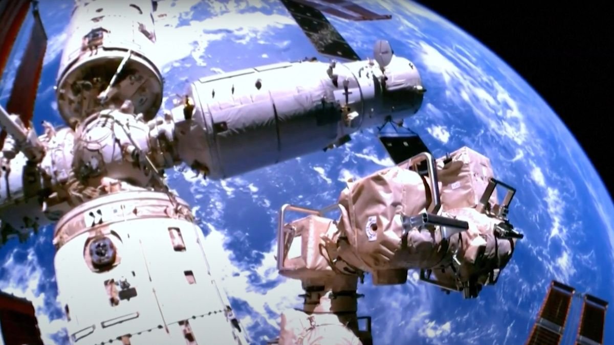 a three module space station seen up close with earth in the background