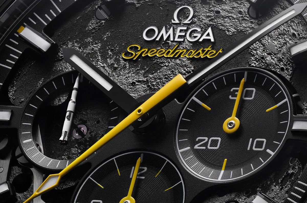 closeup of an omega speedmaster watch face which has a background photo of the moon