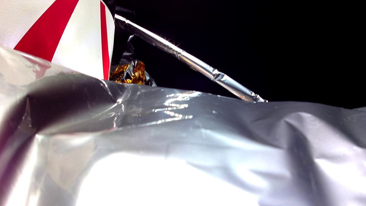 close up of protective tarp surrounding a spacecraft with a strut and black space also visible