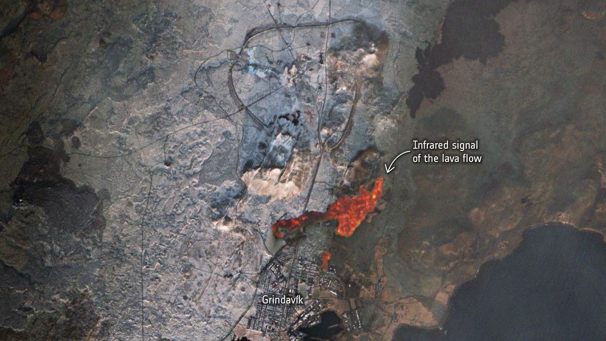 a satellite image of buildings with a glowing pool of lava beside