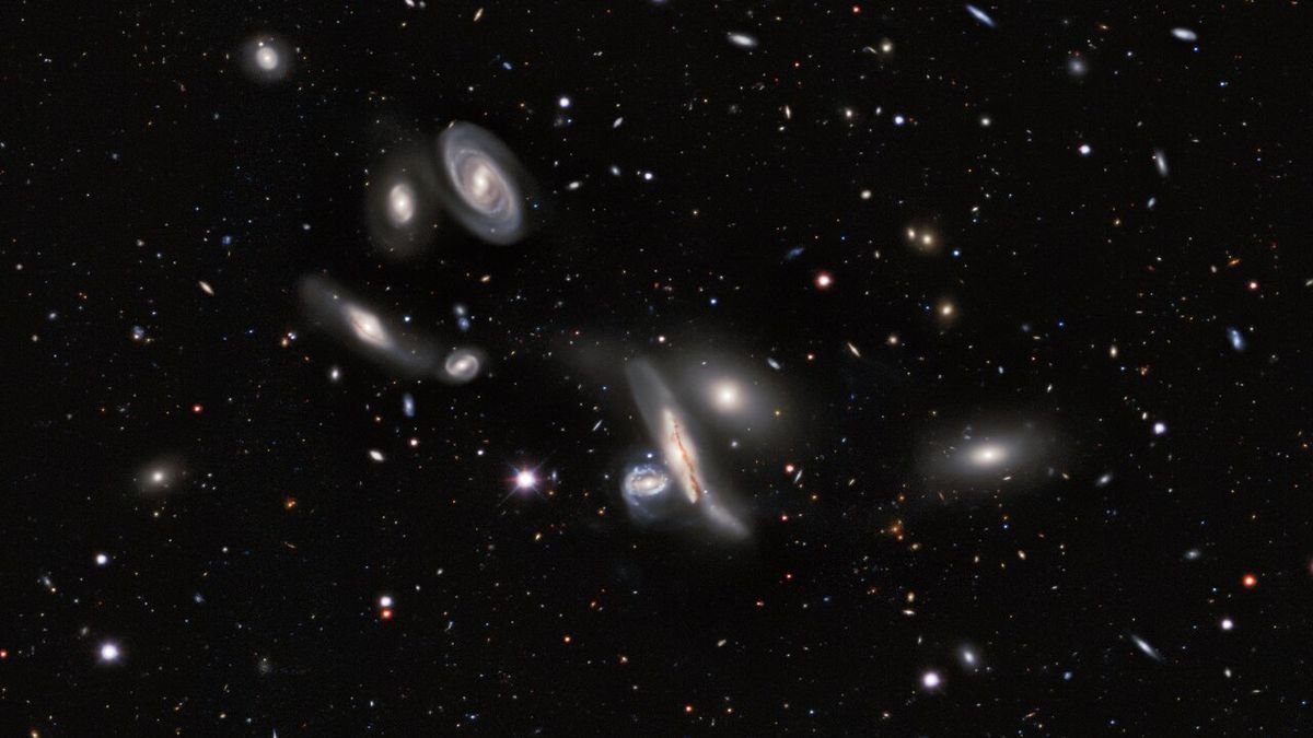 a swarm of galaxies varying in size paints a scattering across black space