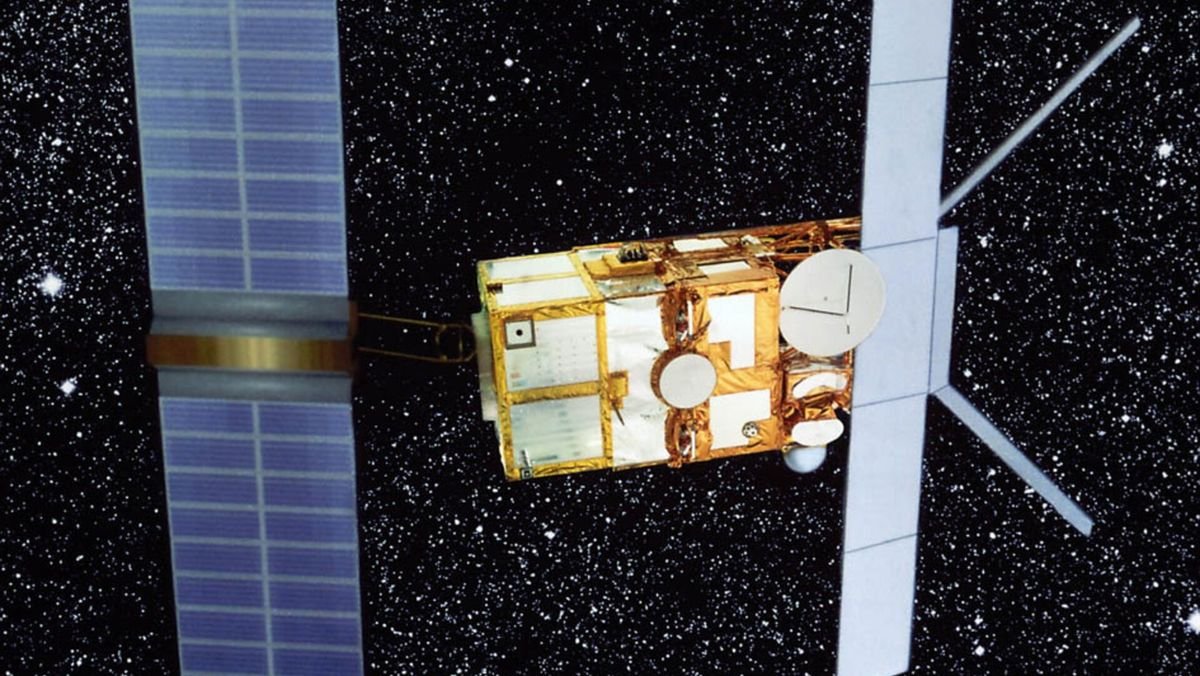 a gold foiled satellite with wide stretch blue solar panels is seen before the black star filled backdrop of space