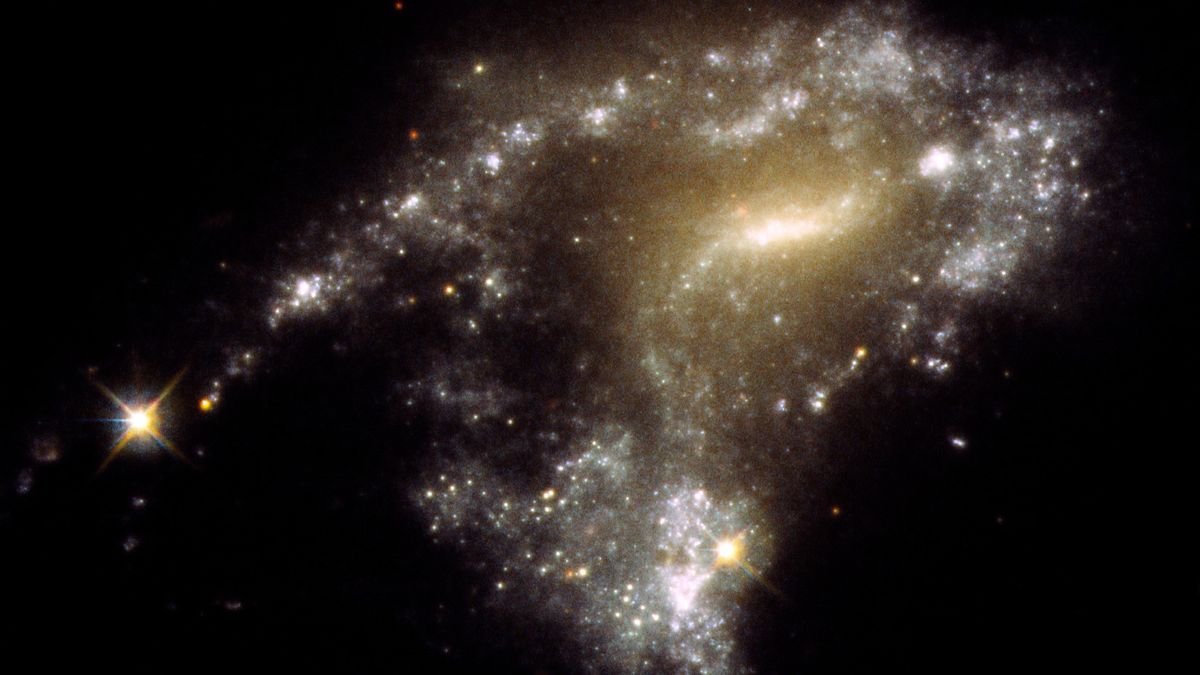 blurry sparkles of white and yellow cluster to form a blurry galaxy