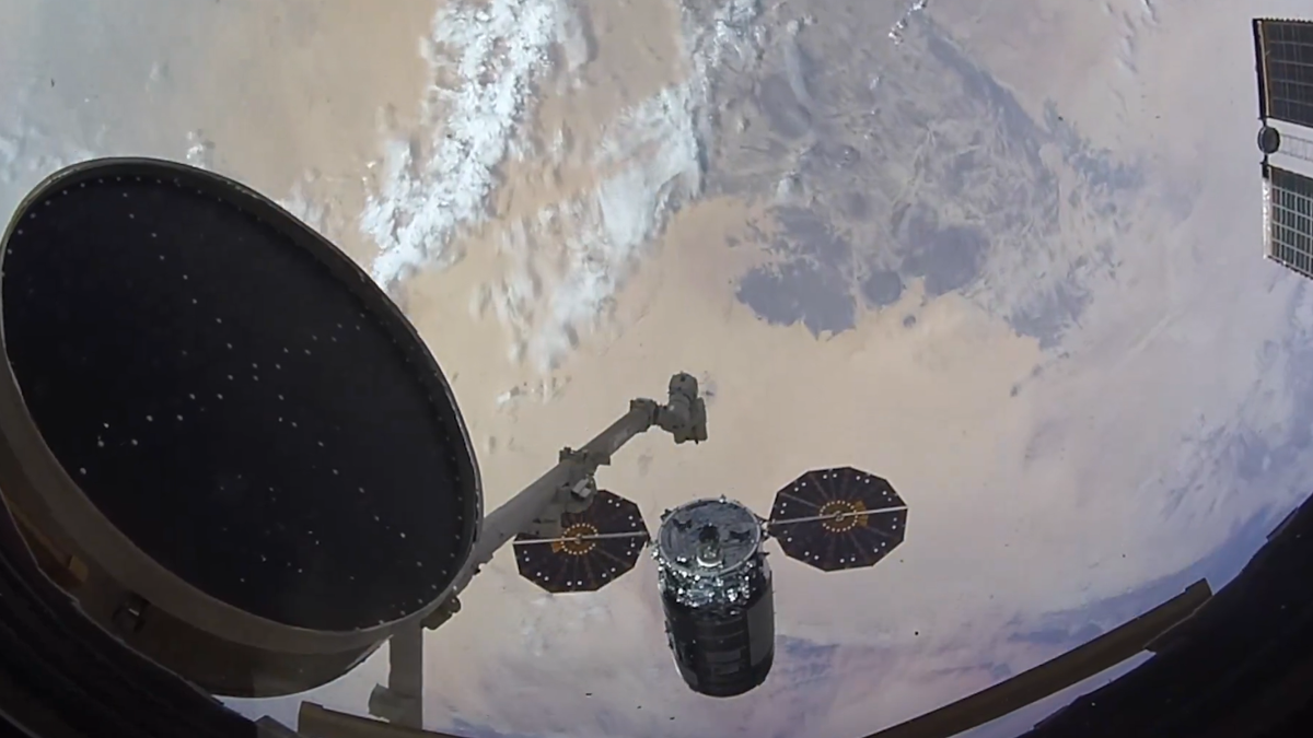a robot arm with a spacecraft floating above earth bits of the international space station like solar panels and modules are visible around the edges