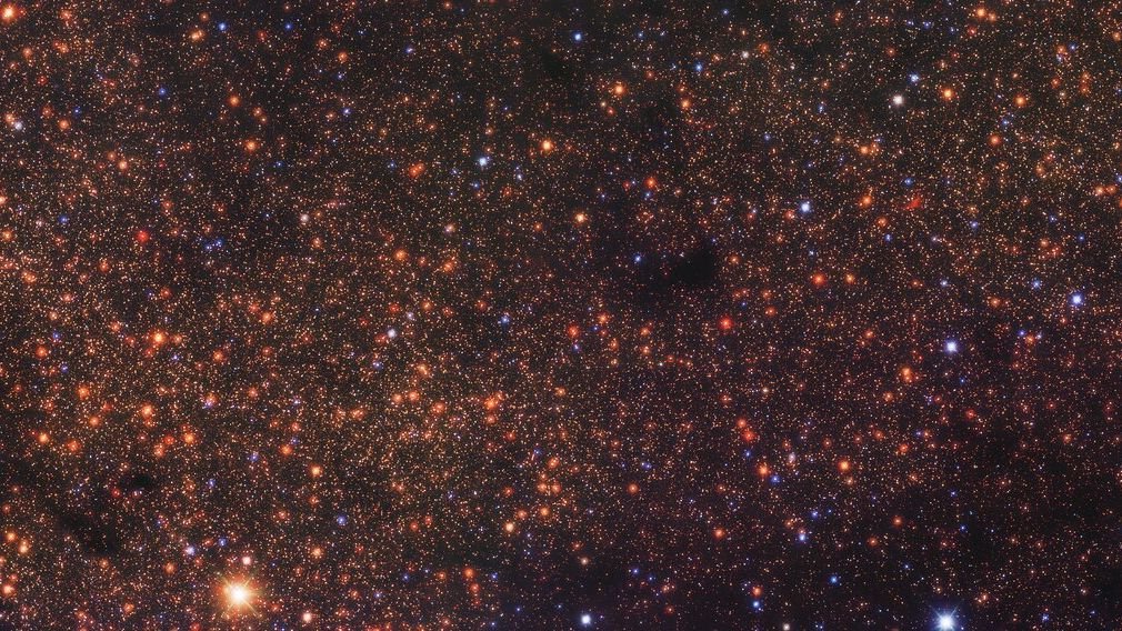 deep space photo showing thousands of reddish orange dots each of which is a distant star
