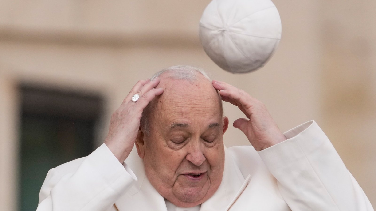 Moment Pope Francis hat sent flying in gust of wind