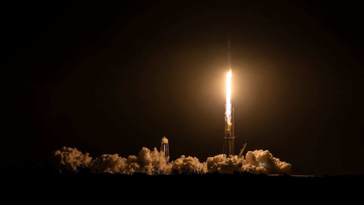 a black and white spacex falcon 9 rocket launches into a night sky