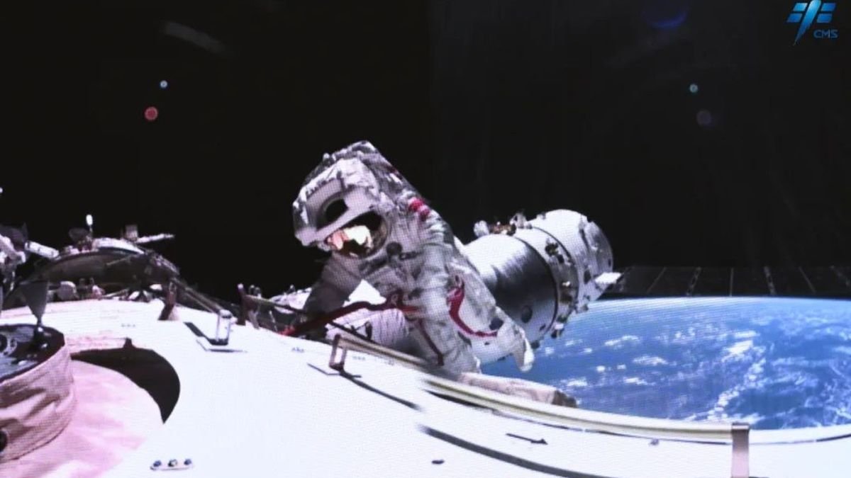 an astronaut in a spacesuit floats outside of a large white cylinder in space earth can be seen in the background