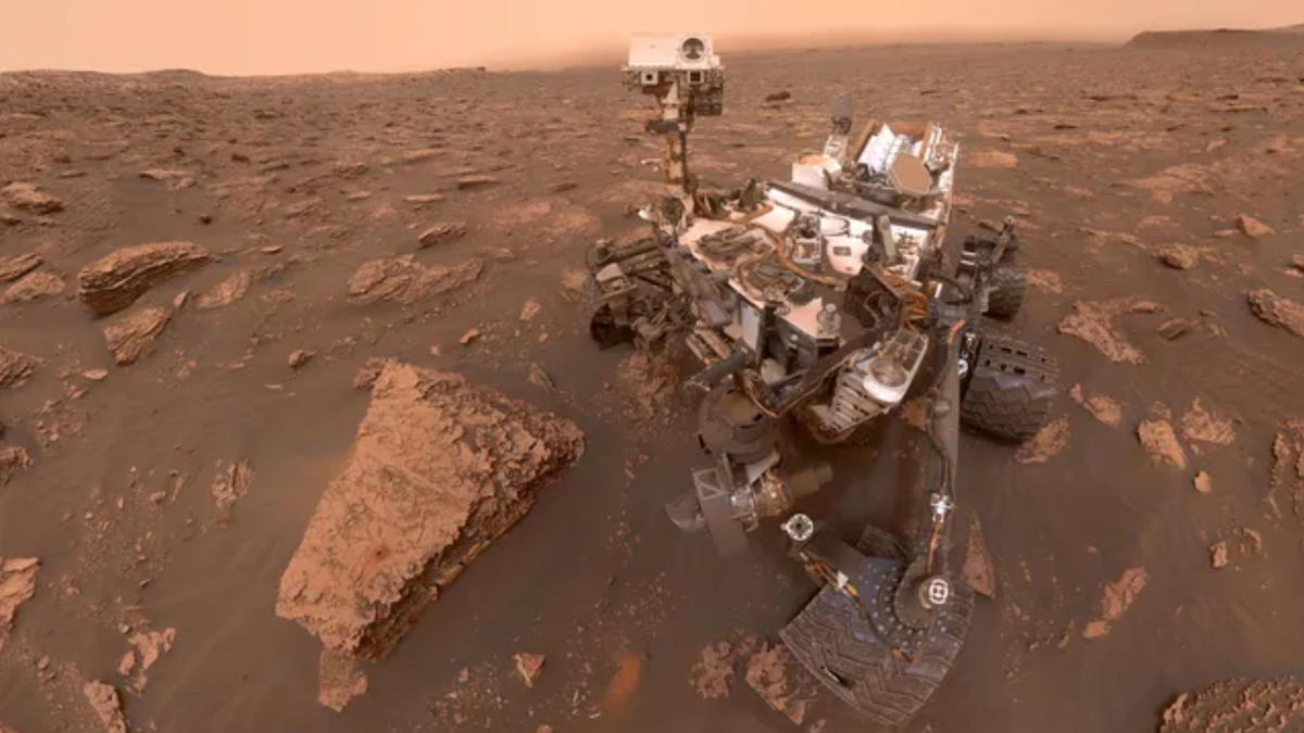 image of a large whitish rover on the surface of mars surrounded by rocks and red dirt