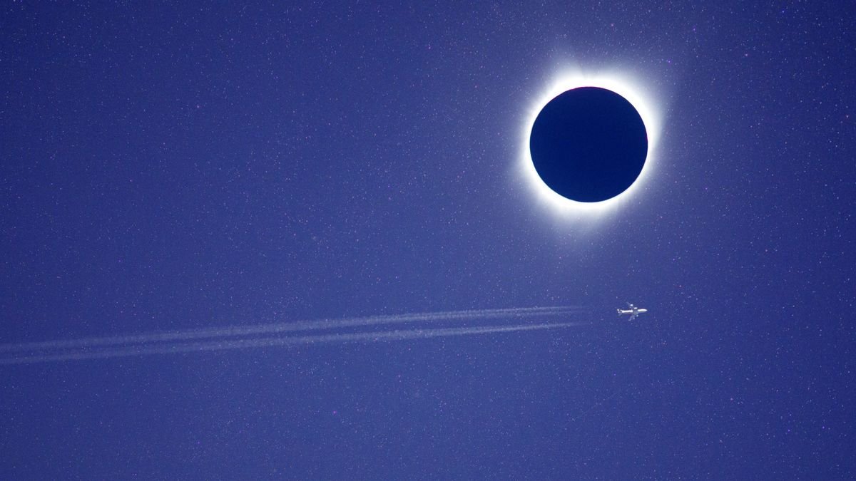 Passenger jet passing across total solar eclipse