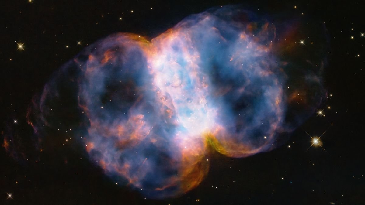 An opaline view of a nebula in space in the shape of a puffy dumbbell