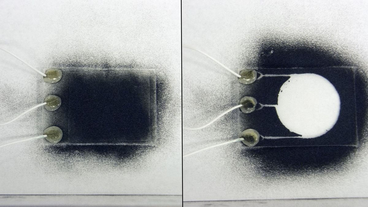 two images the one on the left shows a small rectangle of glass covered in black dust the one on the right shows a clear circle with no dust on the same glass rectangle