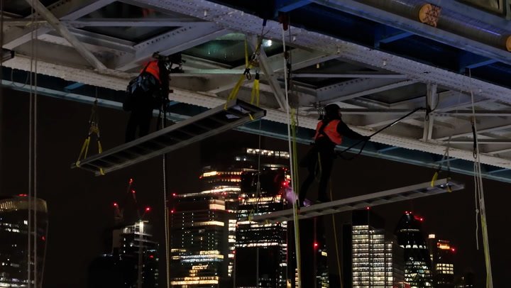 Cleaners dangle from Tower Bridge as underside glass cleaned for first time in decade