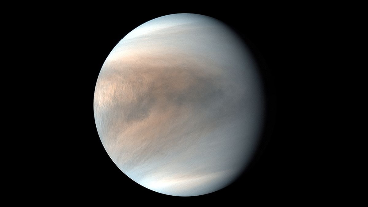 venus with its mottled tan and brown atmosphere is seen against the blackness of space