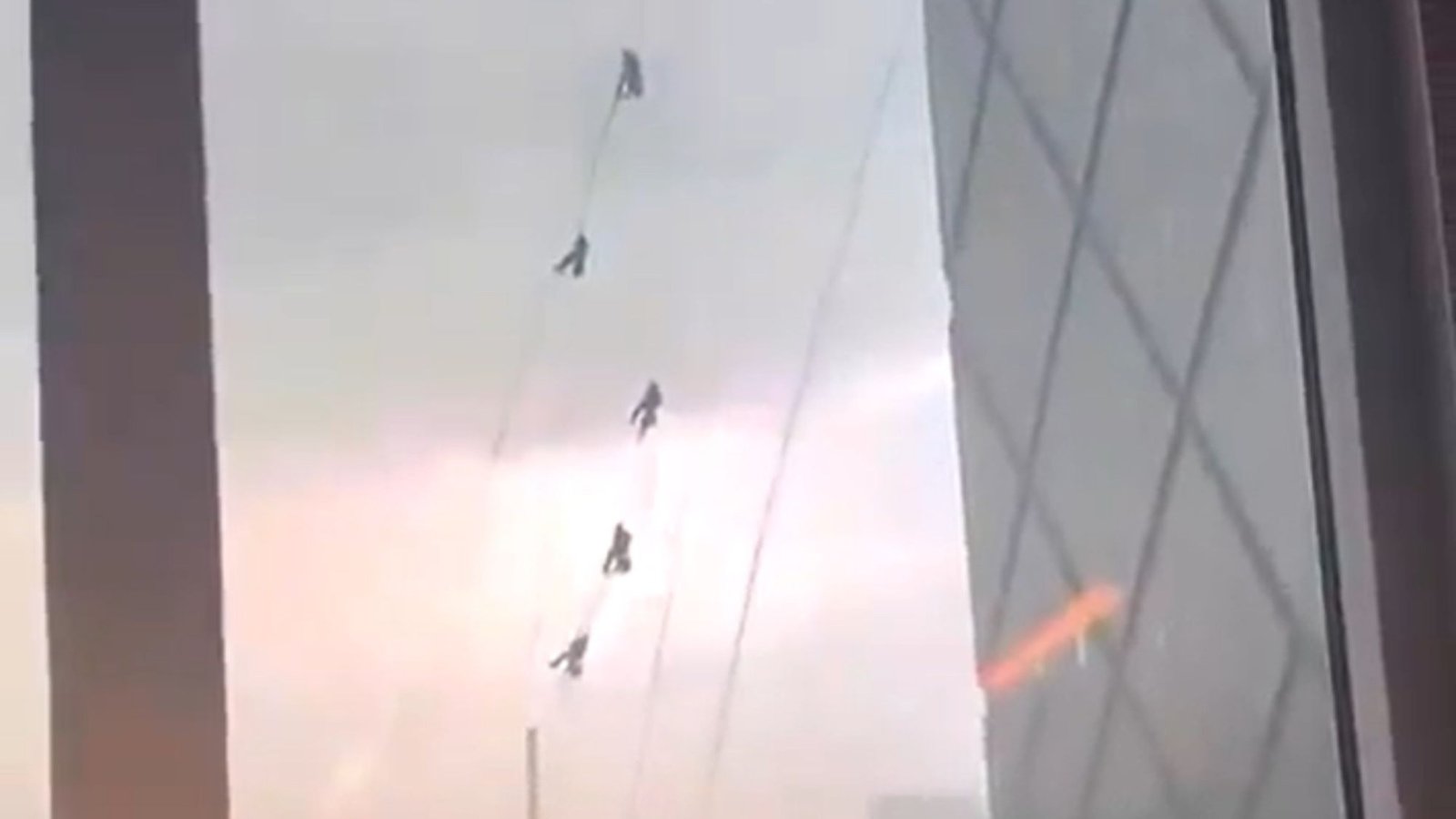 Terrifying moment window cleaners cling on for their lives swinging from 51 storey building as theyre battered by storm