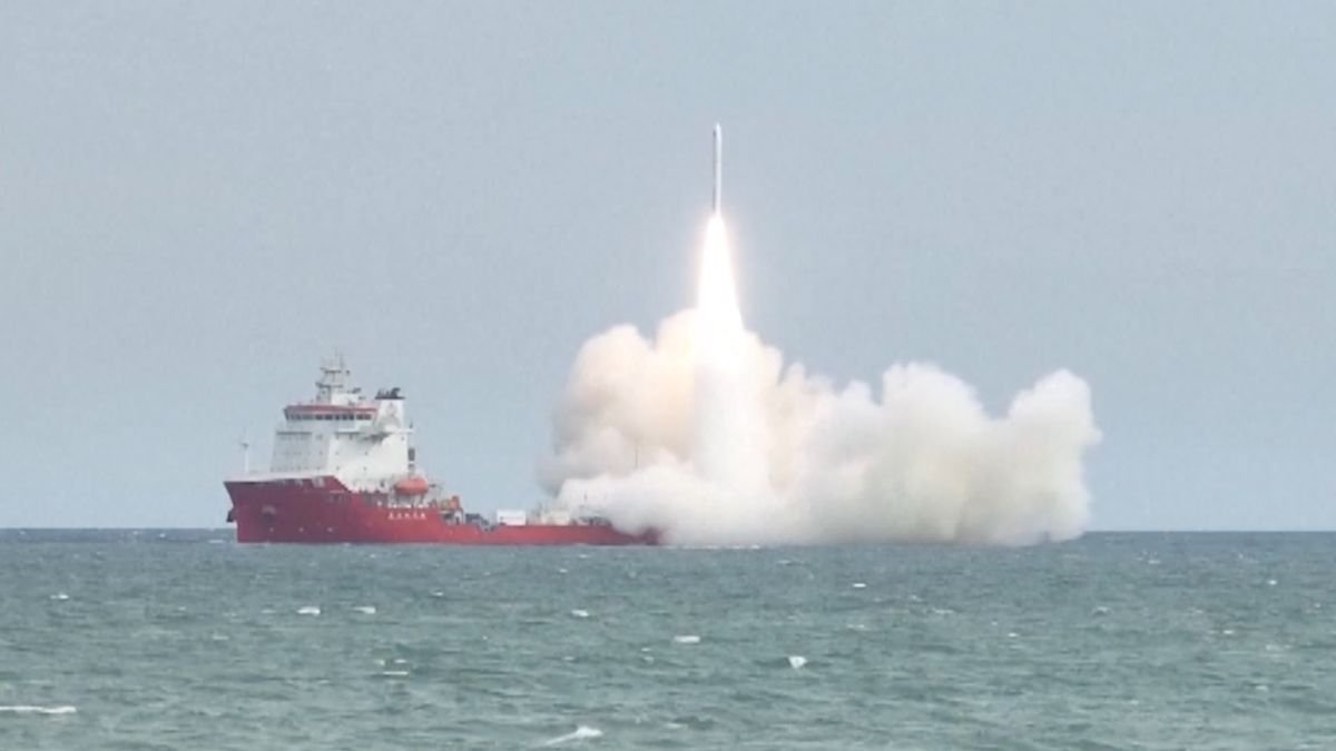 a rocket launches from a red ship at sea