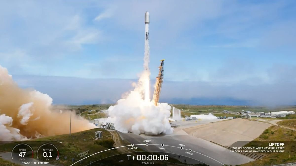 a falcon 9 rocket lifting off on top of a plume with blue sky in the background