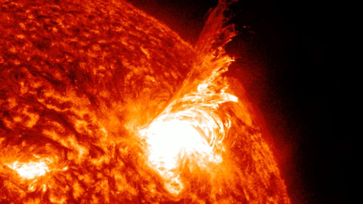 a close up still image of the sun showing a huge fiery looking tendril lashing out from the sun