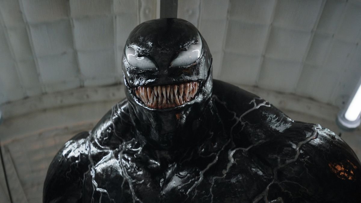 a humanoid creature covered in a thick black goo like substance with a mouth full of long sharp teeth