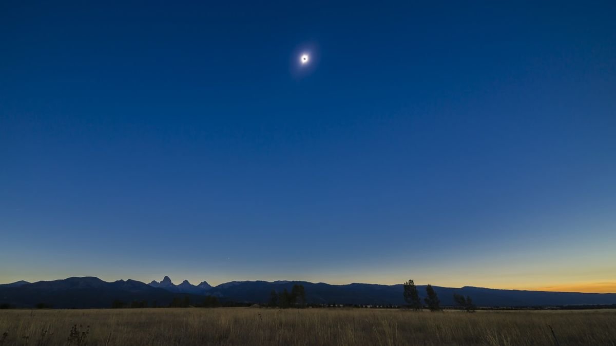 Total solar eclipse over the Grand Tetons as seen from the Teton Valley in Idaho near Driggs This is from a 700 frame time lapse and is of third contact just as the second diamond ring is starting and the dark shadow of the Moon is receding to the east at left The sky is darker to the left but the foregound is beginning to light up as the sky to the west off camera to the right brightens and lights the scene Jupiter is just above the Tetons at bottom