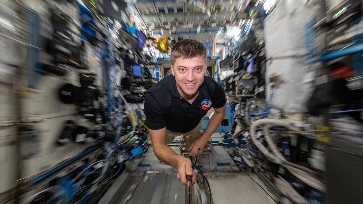 an astronaut on the space station with the background blurry behind him