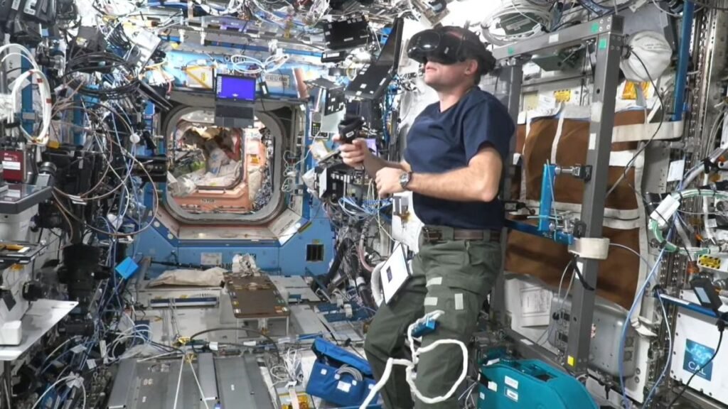 an astronaut wearing a virtual reality headset in a crowded space station module