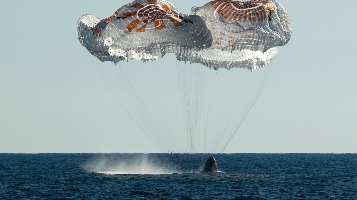 a space capsule splashes down in the ocean on a sunny clear day