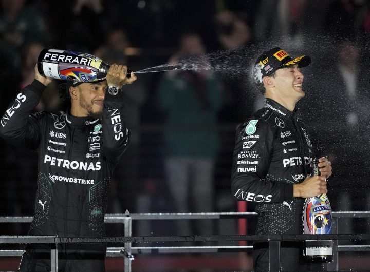 Mercedes driver Lewis Hamilton, of Britain, left, sprays champagne on race winner Mercedes driver George Russell F1 Las Vegas Grand Prix