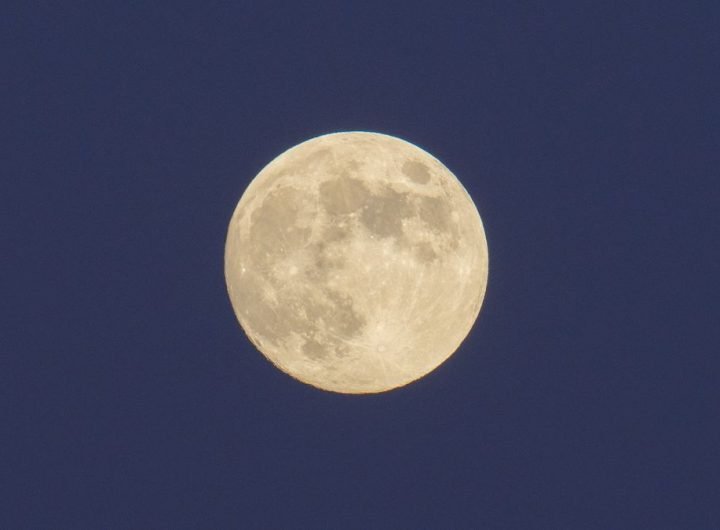 a bright full moon in a dark blue night sky