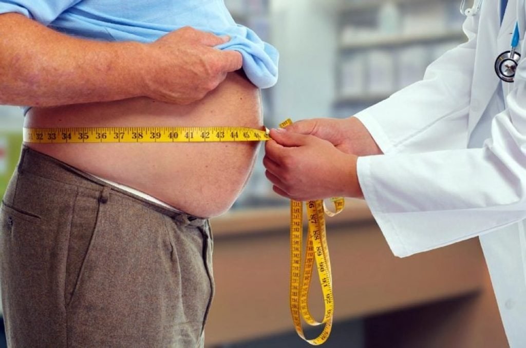 Doctor Measuring Waist Obese Man