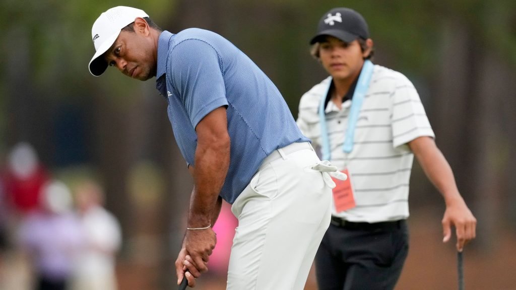 Tiger Woods putts as his son, Charlie watches on the 13th hole during a practice round for the U.S. Open golf tournament Monday, June 10, 2024, in Pinehurst, N.C. (AP Photo/Matt York)