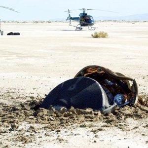 a smashed metal cylinder embedded into the desert floor