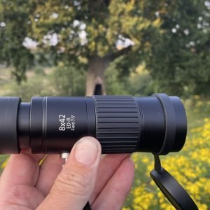 An Opticron Explorer WA ED-R 8x42 monocular held between the author's fingers.