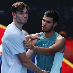 Britain's Jack Draper (L) hugs Spain's Carlos Alcaraz as he retires from their men's singles match on day eight of the Australian Open tennis tournament in Melbourne on January 19, 2025. (Photo by Adrian DENNIS / AFP) / -- IMAGE RESTRICTED TO EDITORIAL USE - STRICTLY NO COMMERCIAL USE --