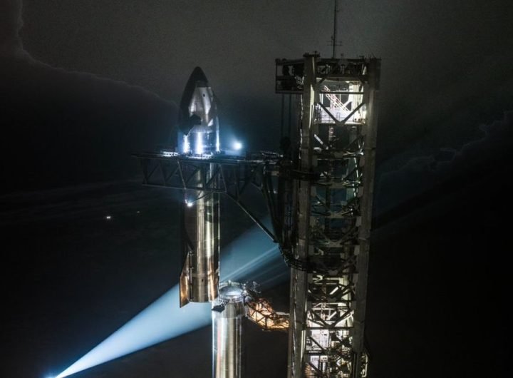 A silver stainless-steel SpaceX Starship is assembled for launch on the pad for Flight 7.